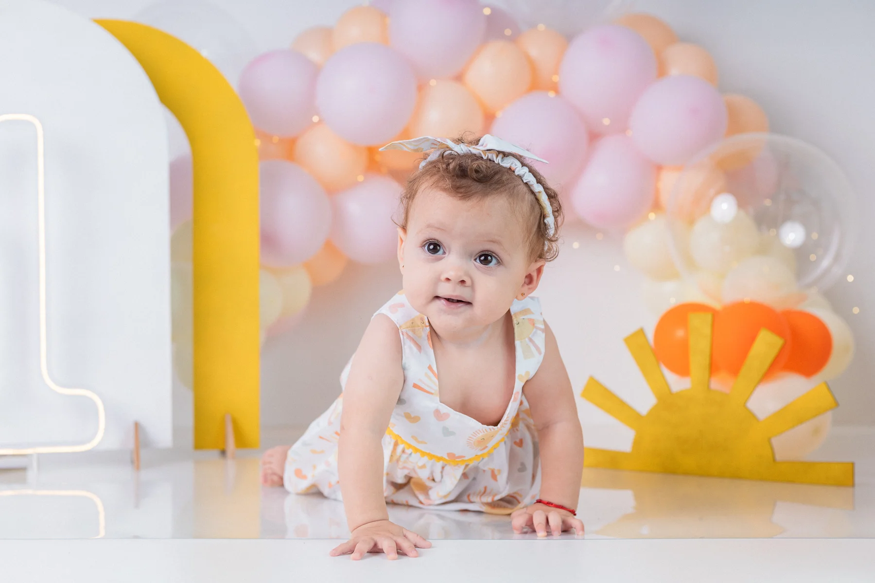 Bebê em cenário claro com bolo de aniversário